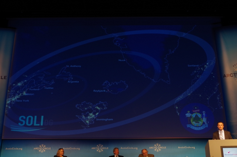 Cost geography map of the North Atlantic for the Maine Port Authority behind. U.S. Senator Lisa Murkowski addresses Arctic Circle 2014 in Reykjavik, Iceland. © Mia Bennett.